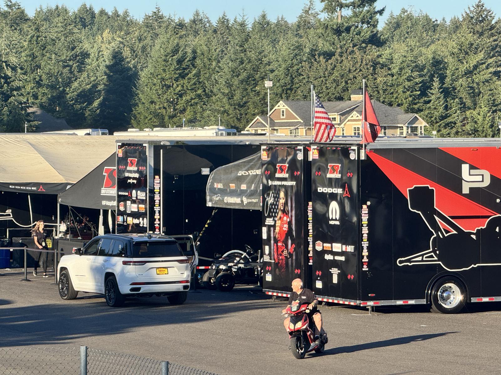 The Tony Stewart Racing transporter and pit area at Pacific Raceways during the 2026 NHRA season, with Leah Pruett’s car livery on the trailer.